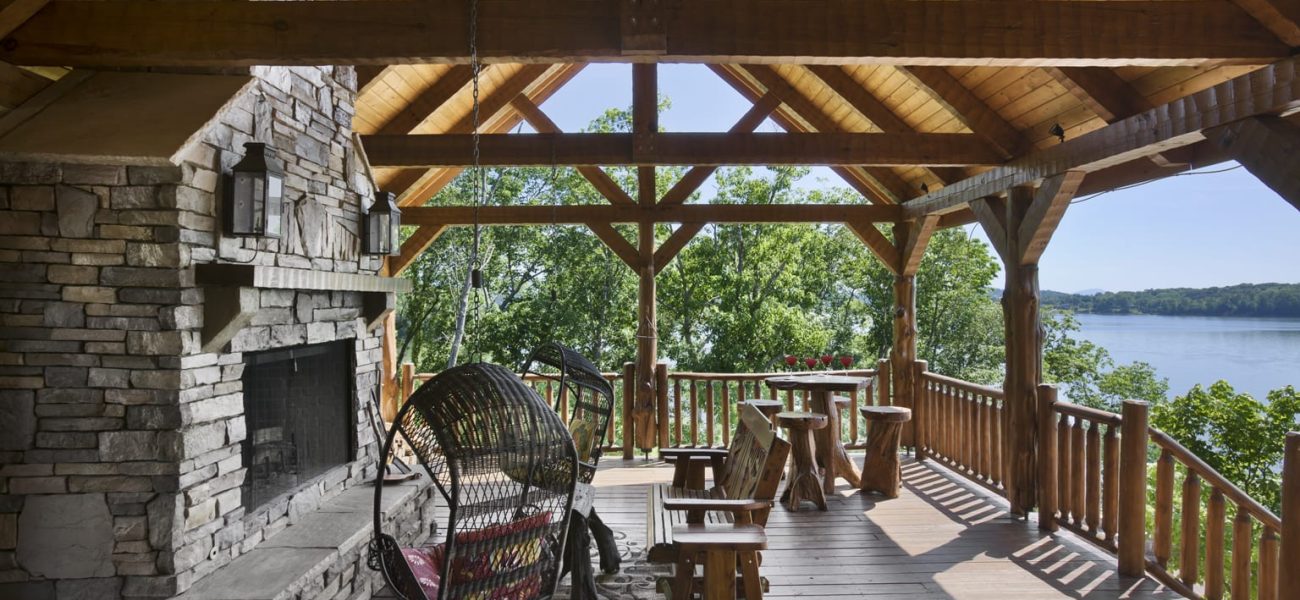 Exterior, horizontal, covered deck with fireplace looking out to Douglas Lake, Kolar residence, Dandridge, Tennessee; Hearthstone Homes